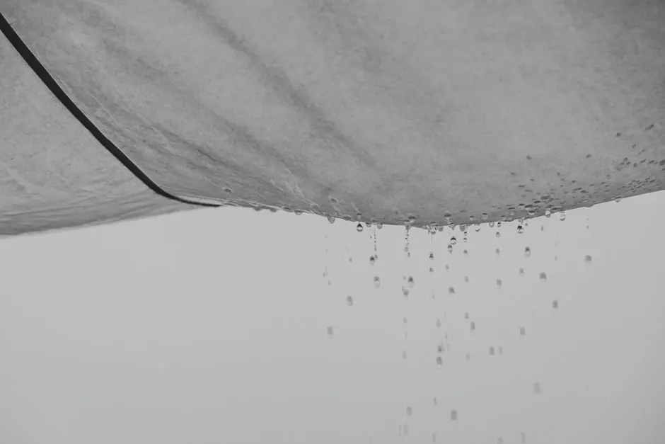 Black and white composition of water drops falling from rag material on gray background